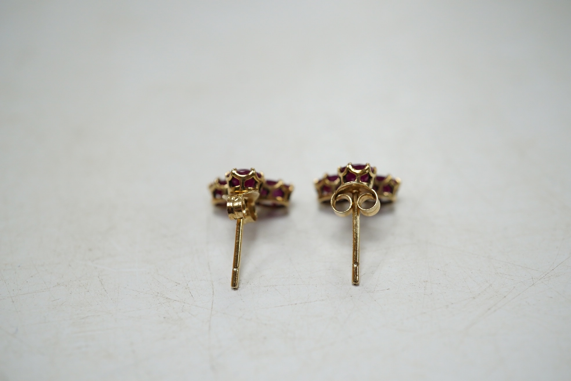 A modern pair of 9ct gold and three stone ruby cluster set ear studs, 9mm, gross weight 1.6 grams. Condition - good